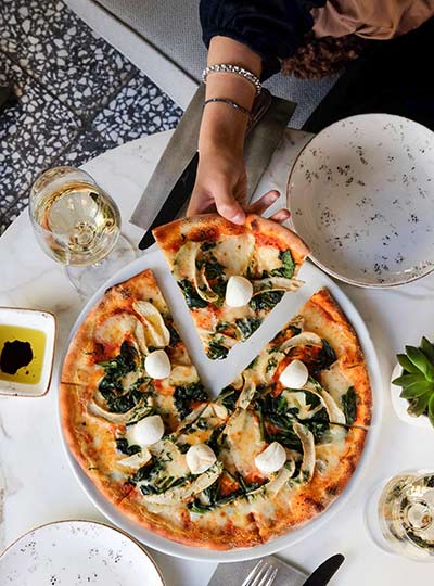 Person taking slice of pizza